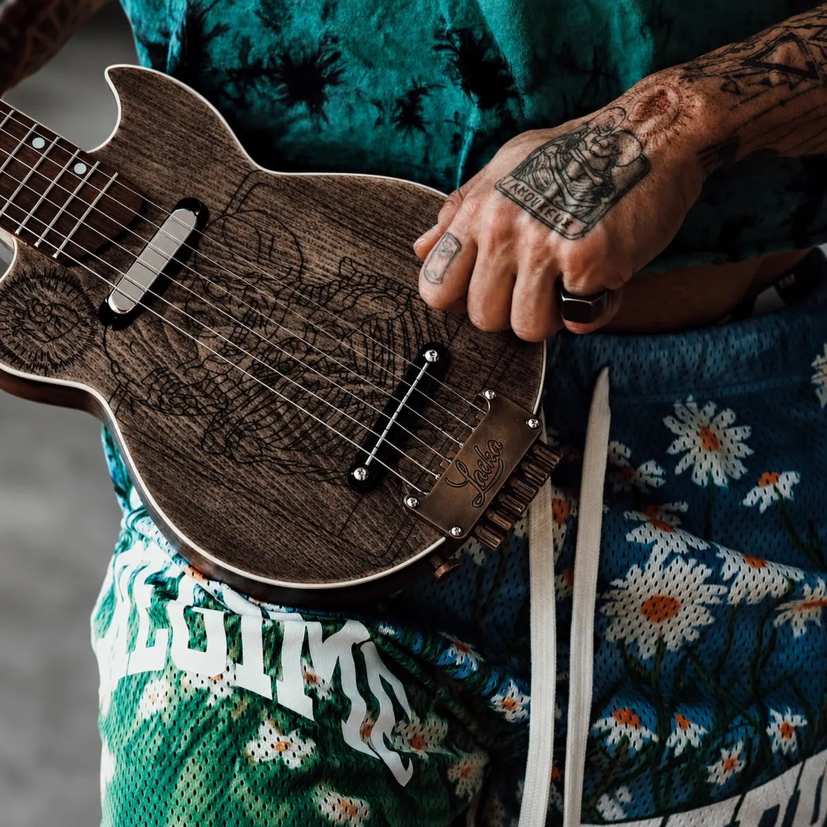 A Laika travel guitar in a player's hands, close up